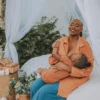 African woman nursing her baby in an brown coat